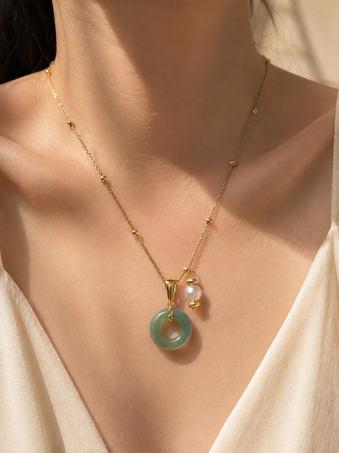 Natural jade donut necklace with pearl accent worn on model
